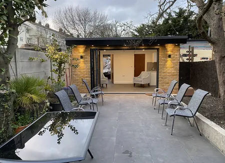 Garden room opening onto a paved terrace
