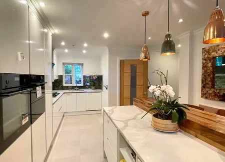 Kitchen with white cabinetry and brass pendant lighting