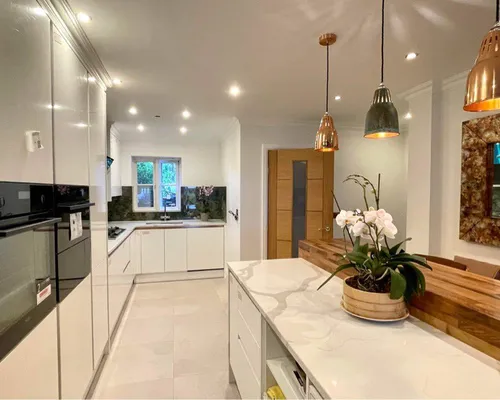 Kitchen with white cabinetry and brass pendant lighting